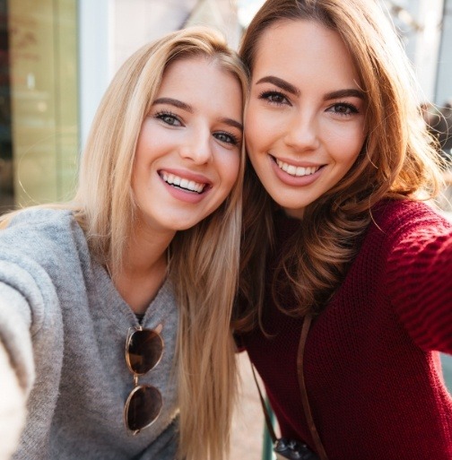 Two women with flawless smiles after dental bonding treatment