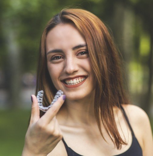 Woman holding an Invisalign tray