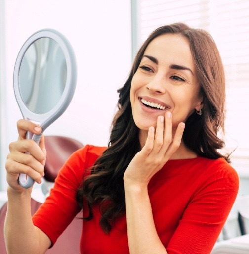 Woman looking at smile after makeover