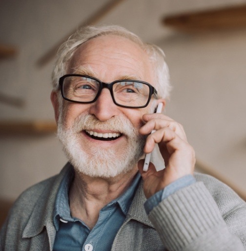 Man discussing cost of dental crown restoration with his dental office