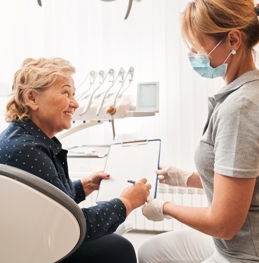 Dentist and patient discussing care plan after dental crown restoration