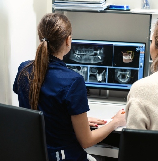 Dental team members looking at digital dental x-rays