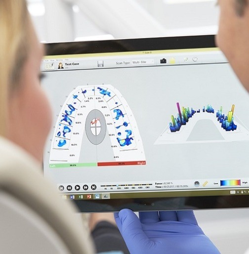 Dentist and patient looking at cavity detection system report