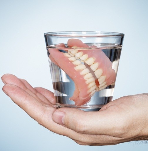 Set of dentures in a glass of water