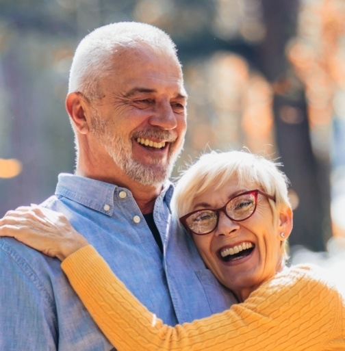 Smiling man and woman with dentures