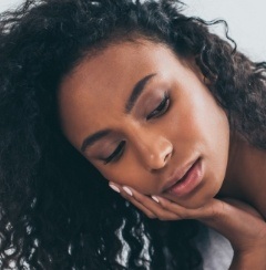 Woman with toothache holding jaw