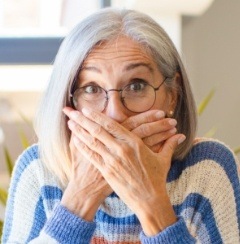 Woman with knocked out tooth covering her mouth