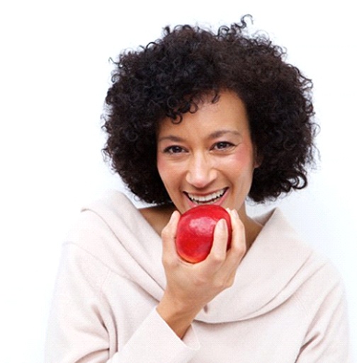 woman biting into a red apple