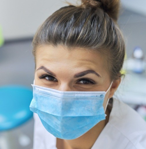 Smiling dental team member wearing a face mask