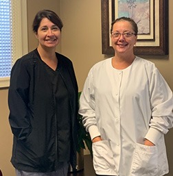 Two smiling dental team members