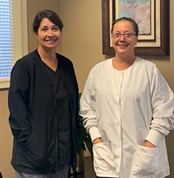 Two smiling dental team members