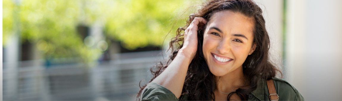 Young woman with perfected smile after Invisalign clear braces treatment