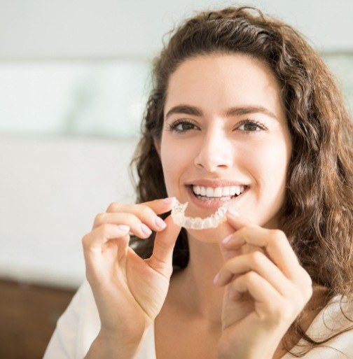 Woman placing Invisalign tray