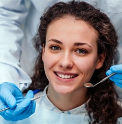 woman with curly hair smiling at her dental checkup 