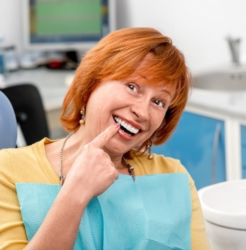 Woman pointing to smile after dental checkup and teeth cleaning