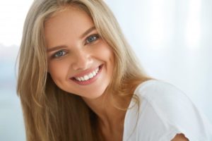 Blonde woman smiling in white shirt