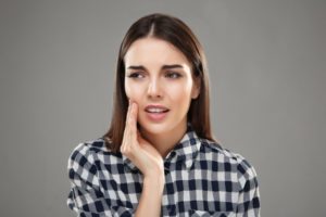 Woman with hand on cheek due to dental pain