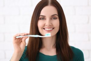 Woman smiling while holding a toothbrush