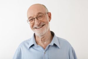 Older man smiling while wearing a collared shirt