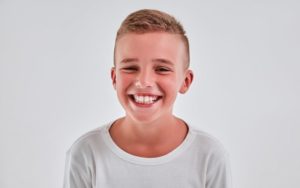 Young boy in white shirt smiling