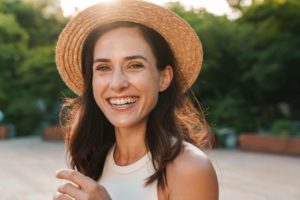 Woman wearing a hat while smiling outside