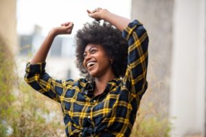 Woman in plaid shirt smiling outside