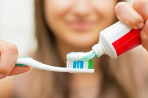 Close up of woman applying toothpaste to toothbrush