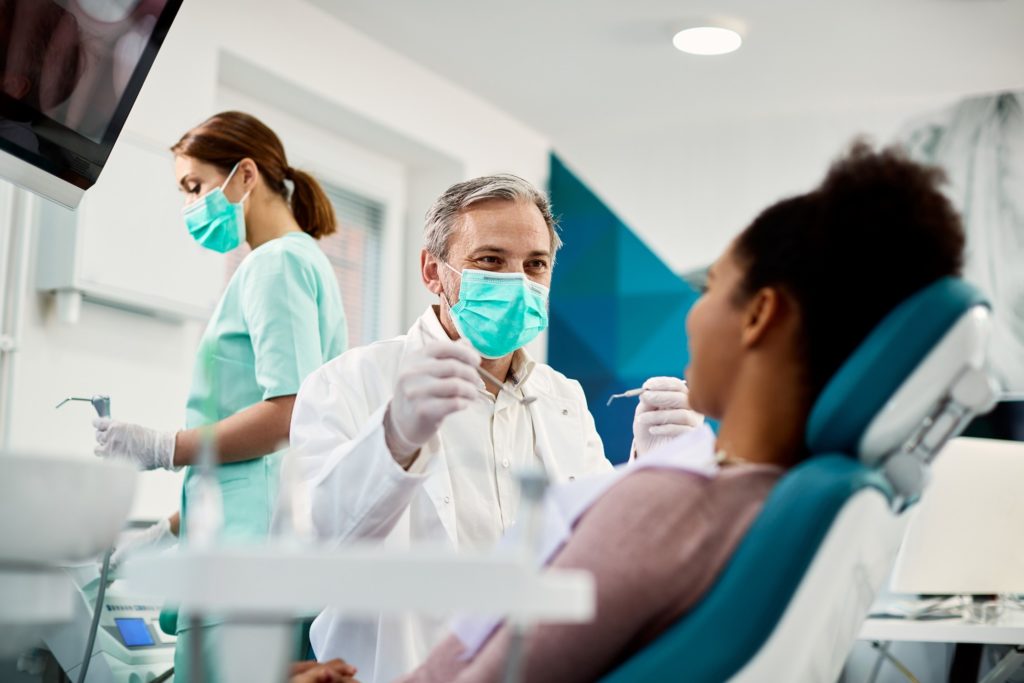 Dentist and patient smiling during routine dental checkup